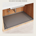 Grey silicone mat covering the floor of a kitchen cabinet under the sink