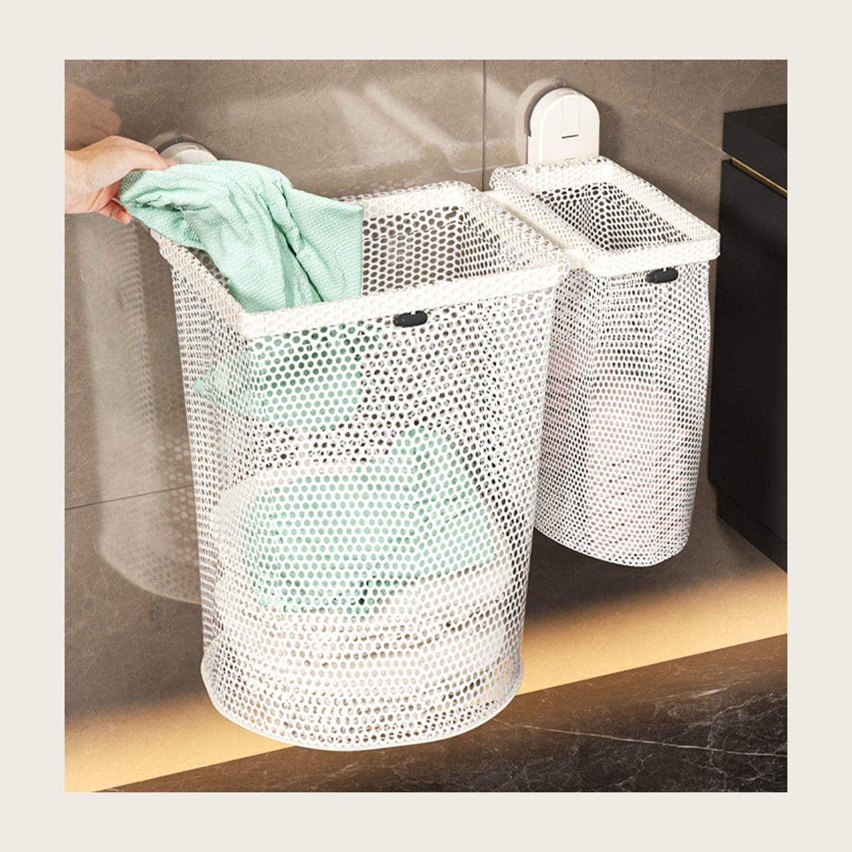 Cream mesh laundry hamper hanging on a bathroom wall, a towel going in
