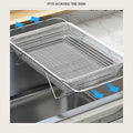 Stainless over-sink rinse basket spanning a kitchen sink with arms on the rim