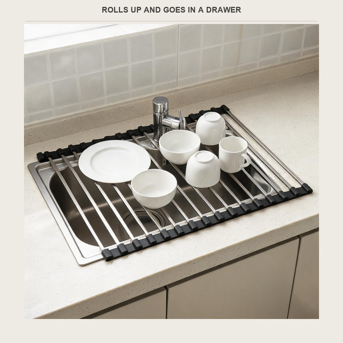 Roll-up stainless drying rack unrolled across a kitchen sink with plates, bowls and mugs on it
