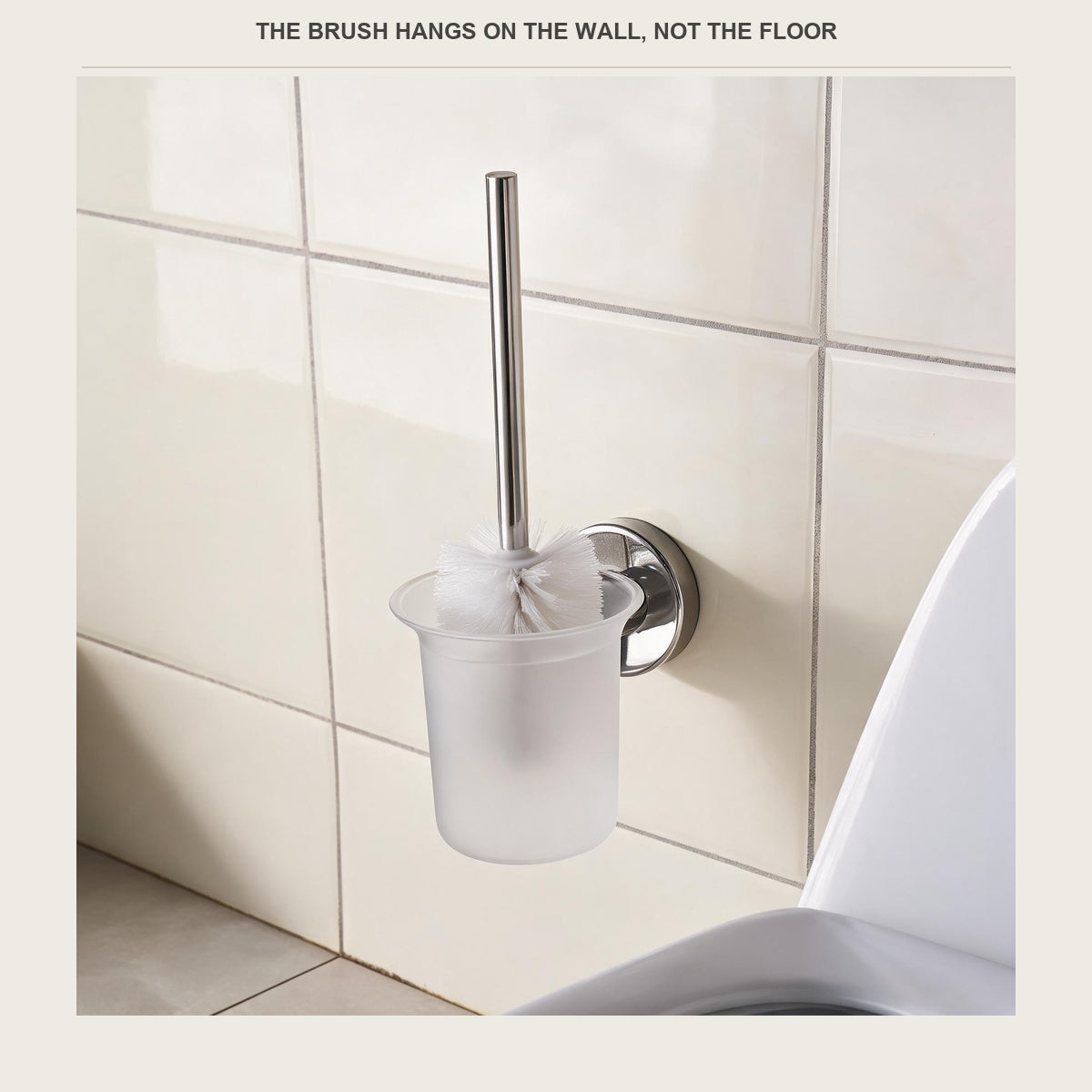 Toilet brush hanging on a tiled bathroom wall beside the bowl