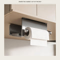 Under-cabinet paper holder mounted below a pale kitchen wall unit, holding a roll of kitchen paper