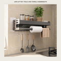 Aluminium wall shelf above a kitchen counter holding spice jars, with utensils on the hooks below