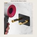 Hair dryer next to a wall-mounted hair tool holder in a bathroom
