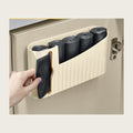 Cream trash bag roll caddy on the inside of a kitchen cabinet door