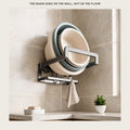 Foldable aluminium wall rack holding two basins on a tiled bathroom wall, with a towel on the hooks below