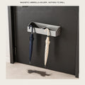 Magnetic umbrella holder clipped to a steel entry door holding a navy and a cream long umbrella