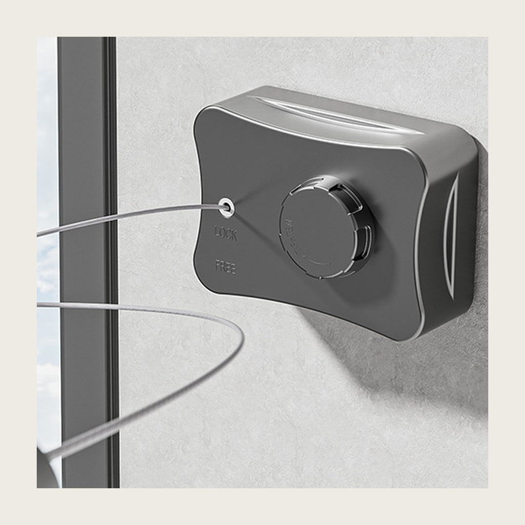 Grey retractable clothesline housing on a bathroom wall with the wire pulled out