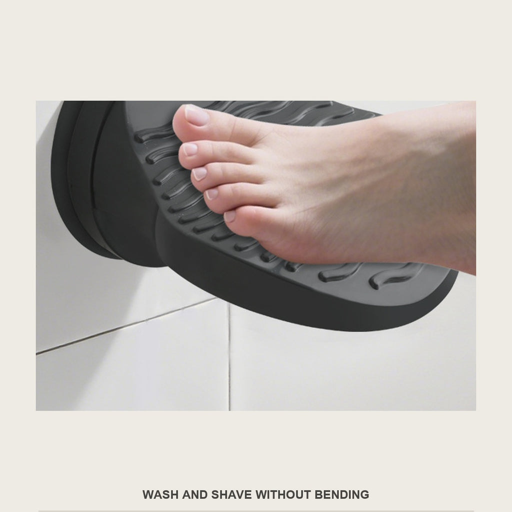 Foot resting on the black shower foot rest while washing in the shower