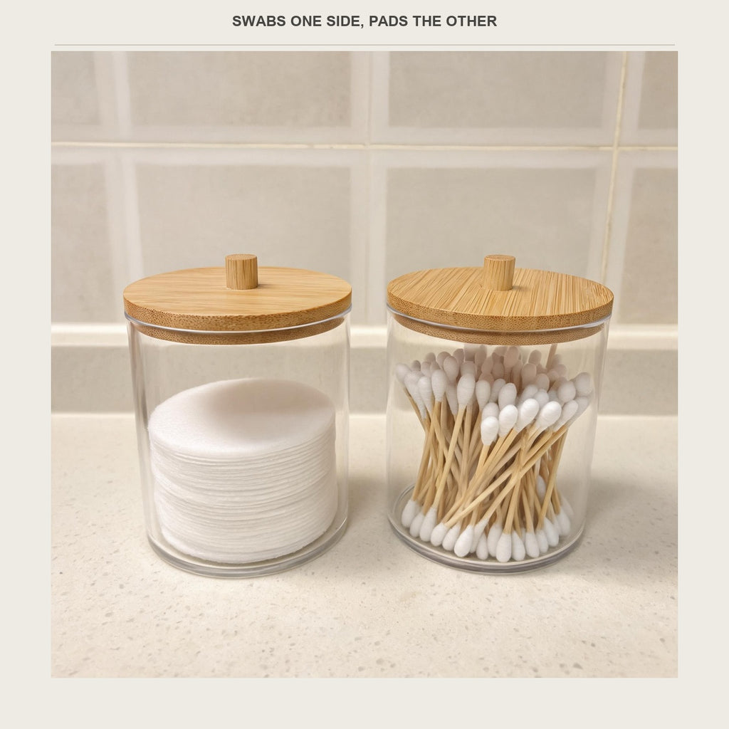 Two acrylic swab jars side by side on a bathroom counter, one holding swabs and one holding cotton pads