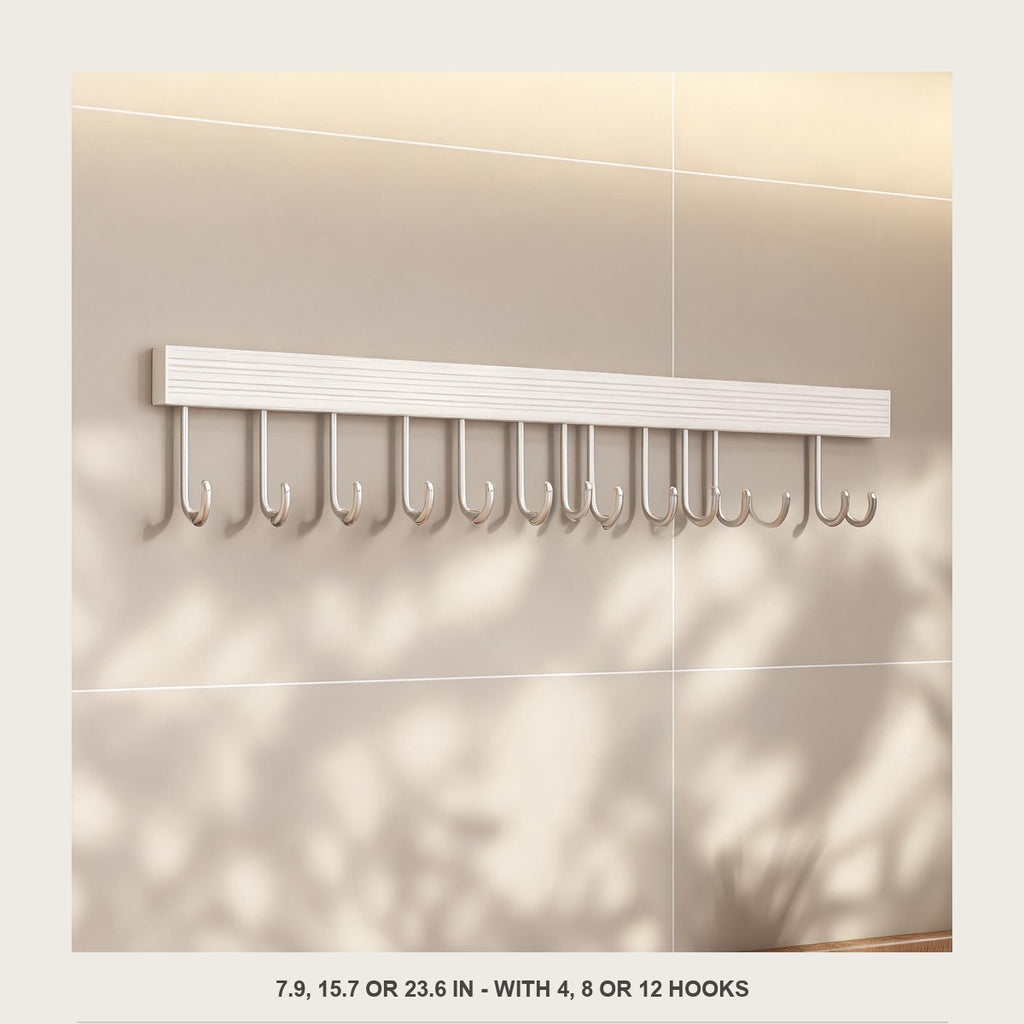 Front view of the empty off white aluminium utensil rail on a plain tiled wall