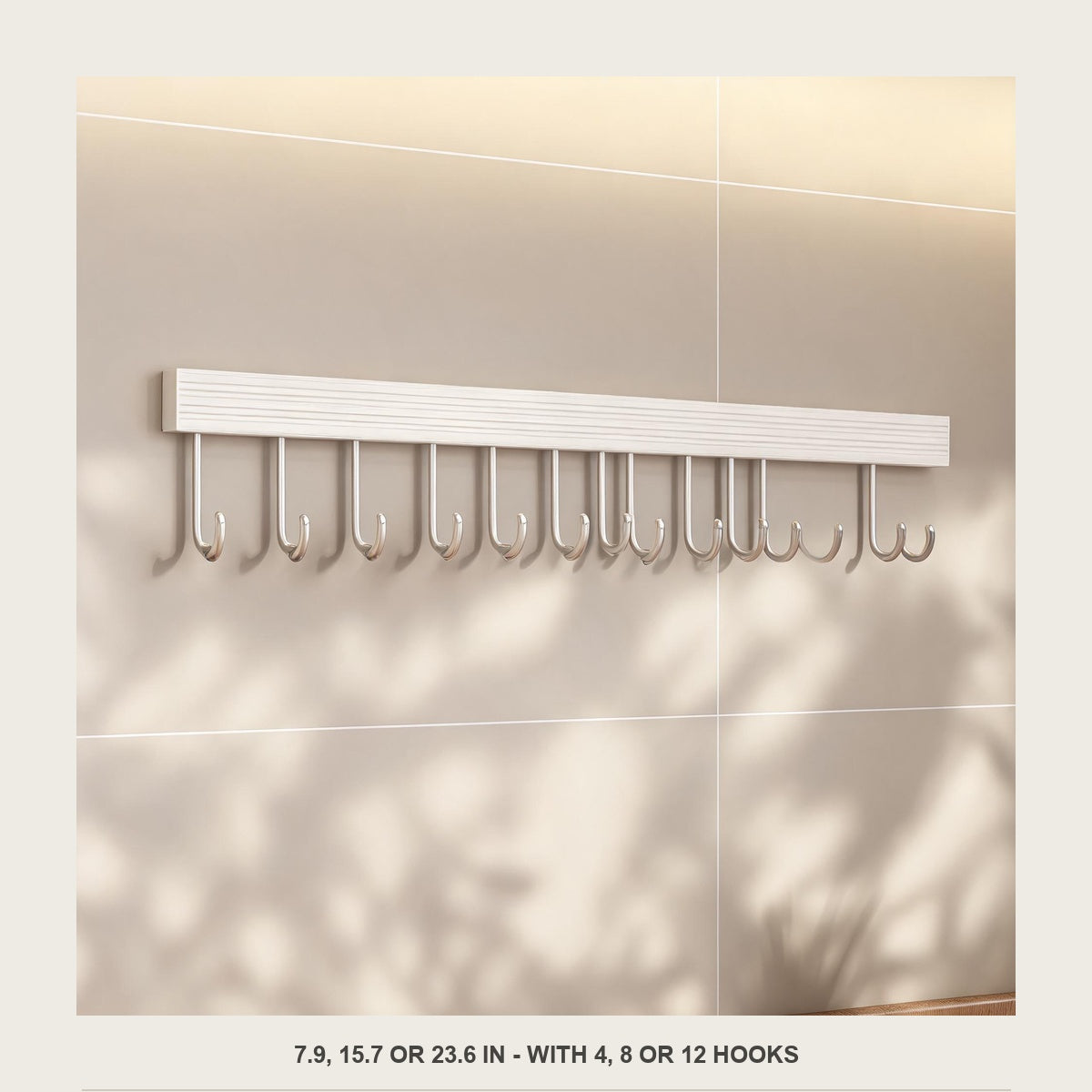 Front view of the empty off white aluminium utensil rail on a plain tiled wall