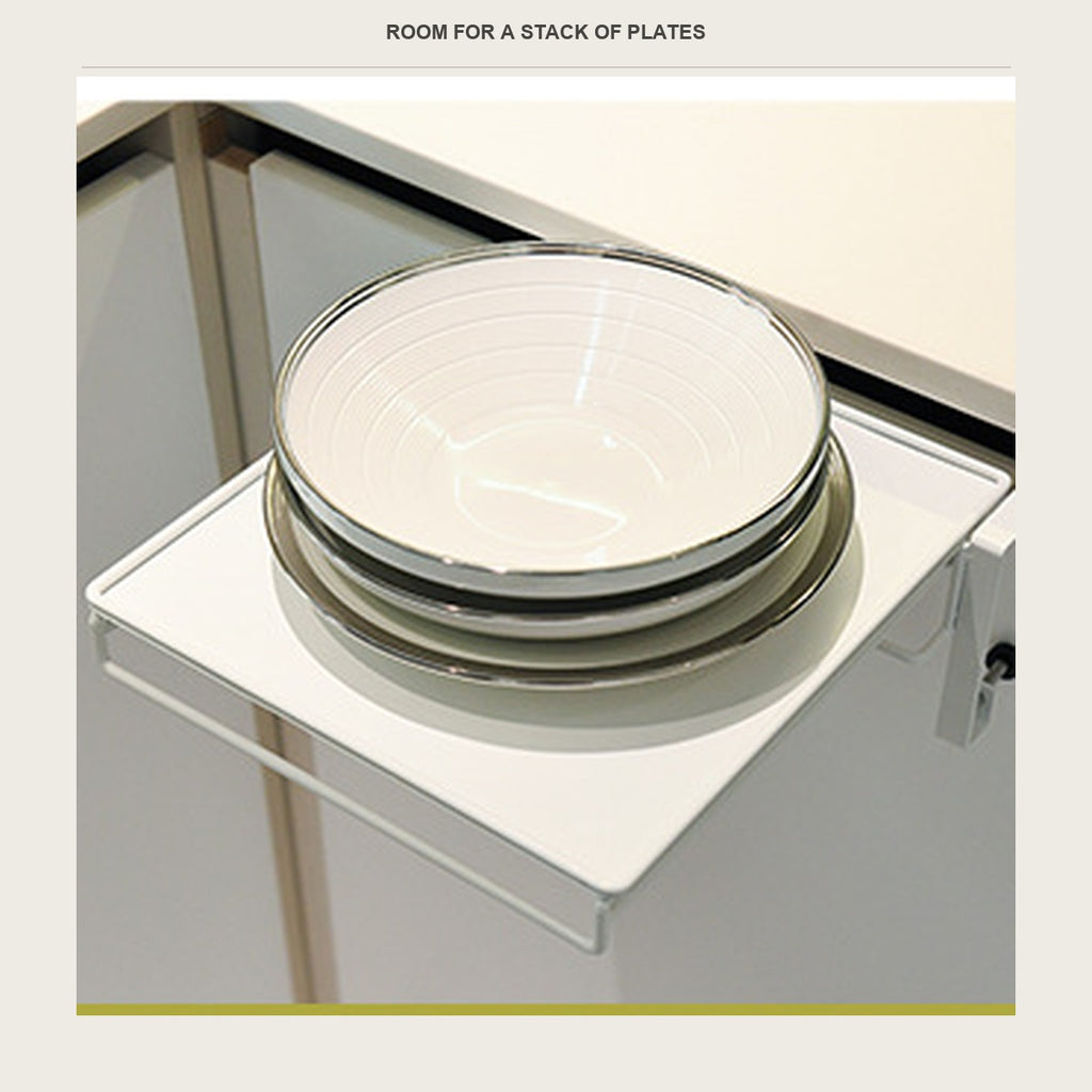 Three dinner plates stacked on the fold-down shelf beside a sink
