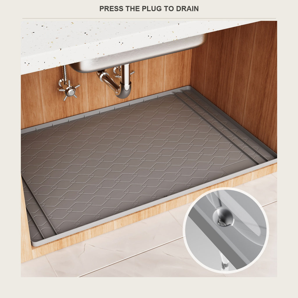 The moulded drain plug in the corner of the cabinet mat