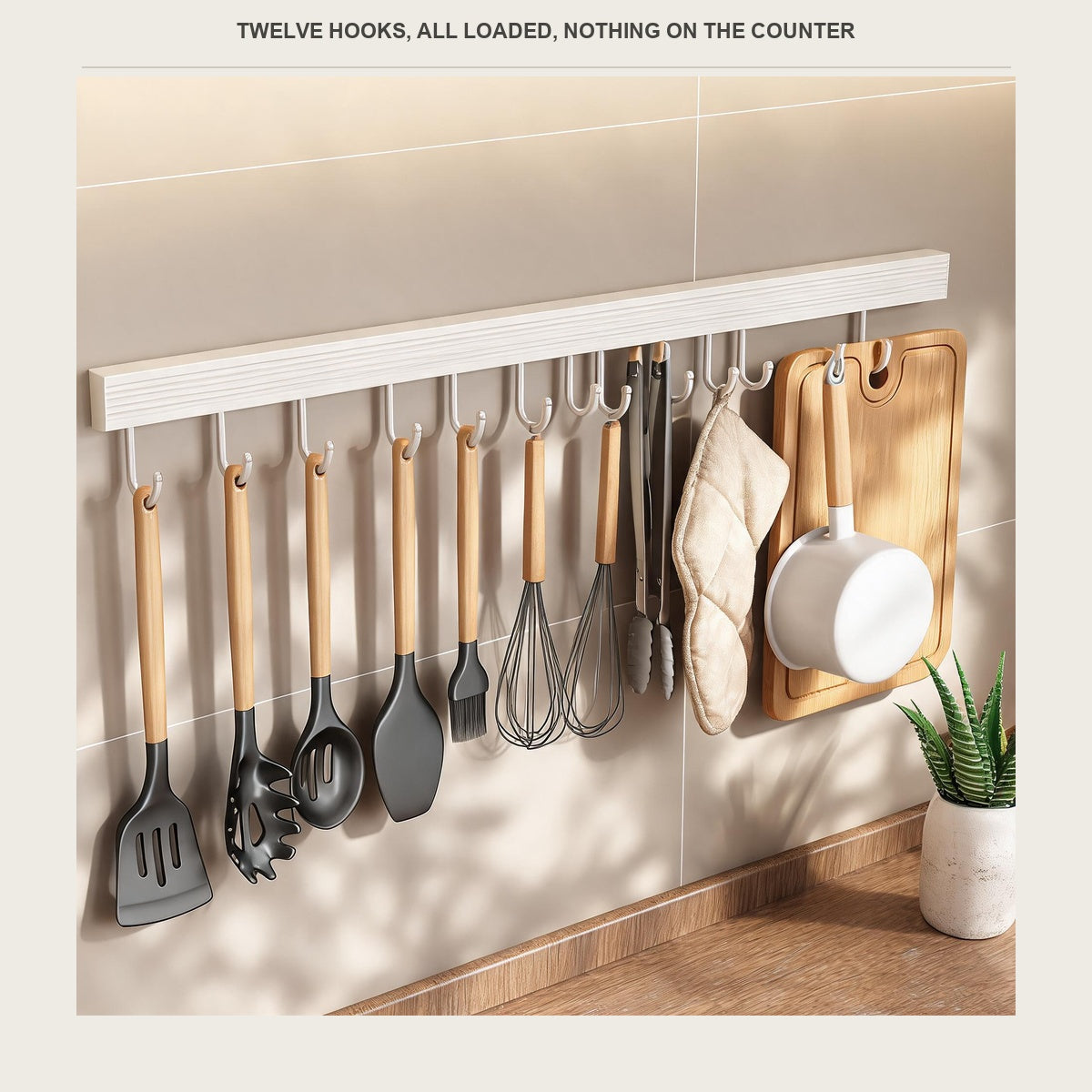 All twelve hooks of the utensil rail loaded with kitchen tools