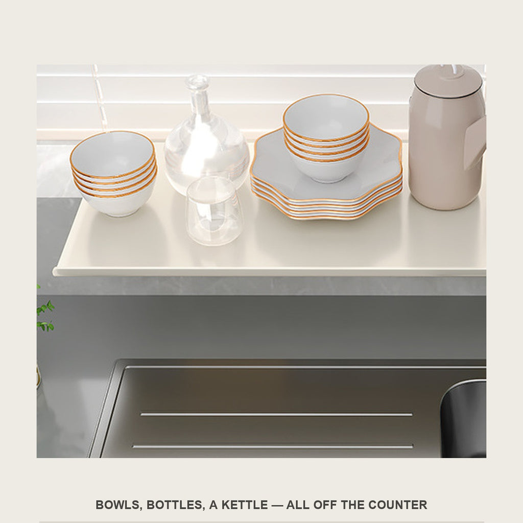 Close view of bowls, a glass carafe and a kettle standing on the sill extension shelf