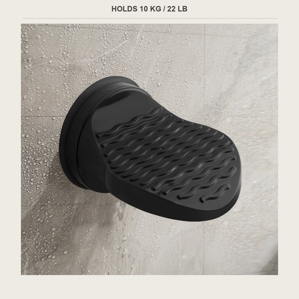 Black shower foot rest on white tile wall, side view