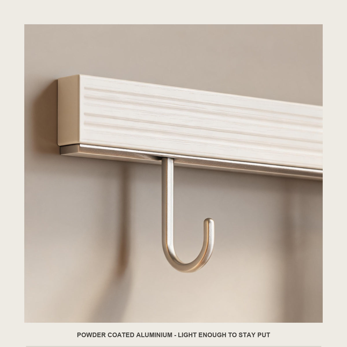 Macro of the powder coated off white bar and one champagne wire hook