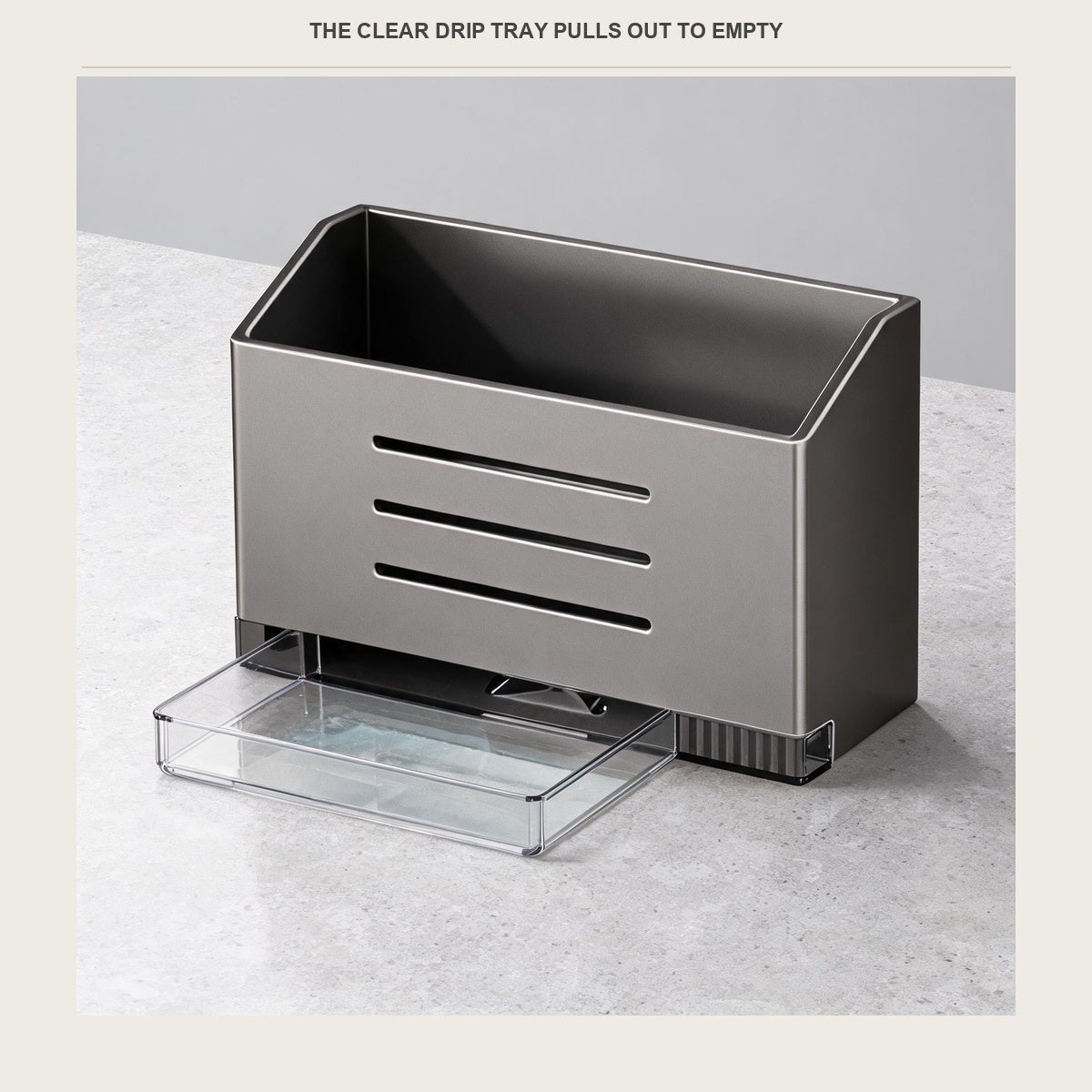 The clear drip tray pulled out from under the umbrella box on a pale countertop