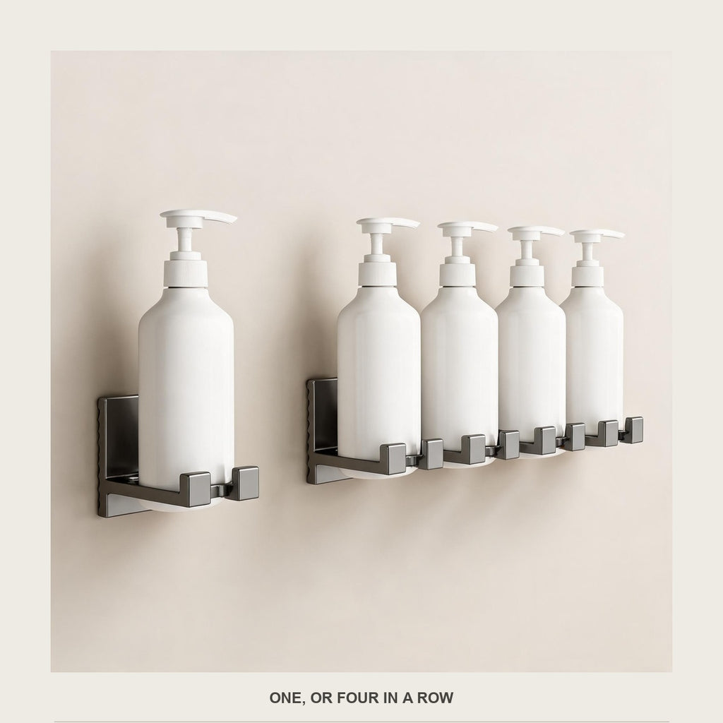 One bottle holder beside a row of four, all empty, on a plain pale background
