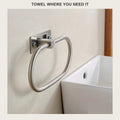 Brushed steel towel ring on a beige bathroom wall above a white sink
