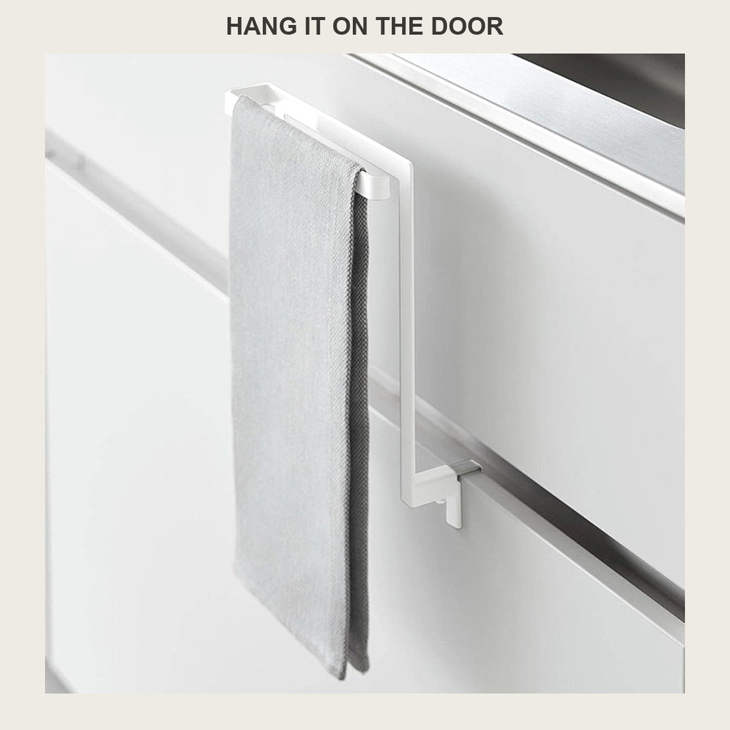 Grey towel hanging on the no-drill rack clamped over a white cabinet door