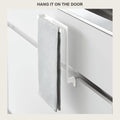 Grey towel hanging on the no-drill rack clamped over a white cabinet door