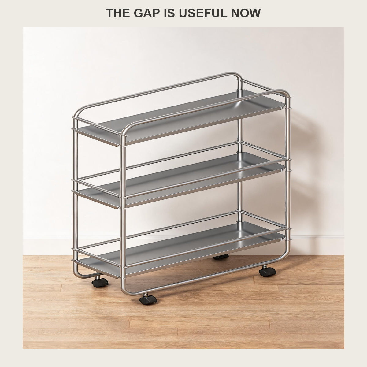 Empty slim three-tier rolling cart with wire rails and castors against a plain white wall