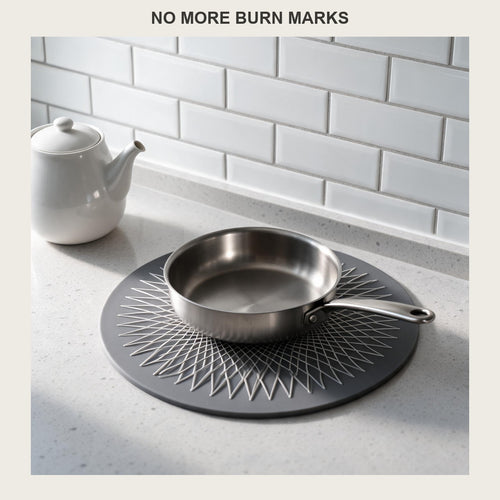 Round silicone trivet mat on a kitchen counter with a stainless pan resting on it