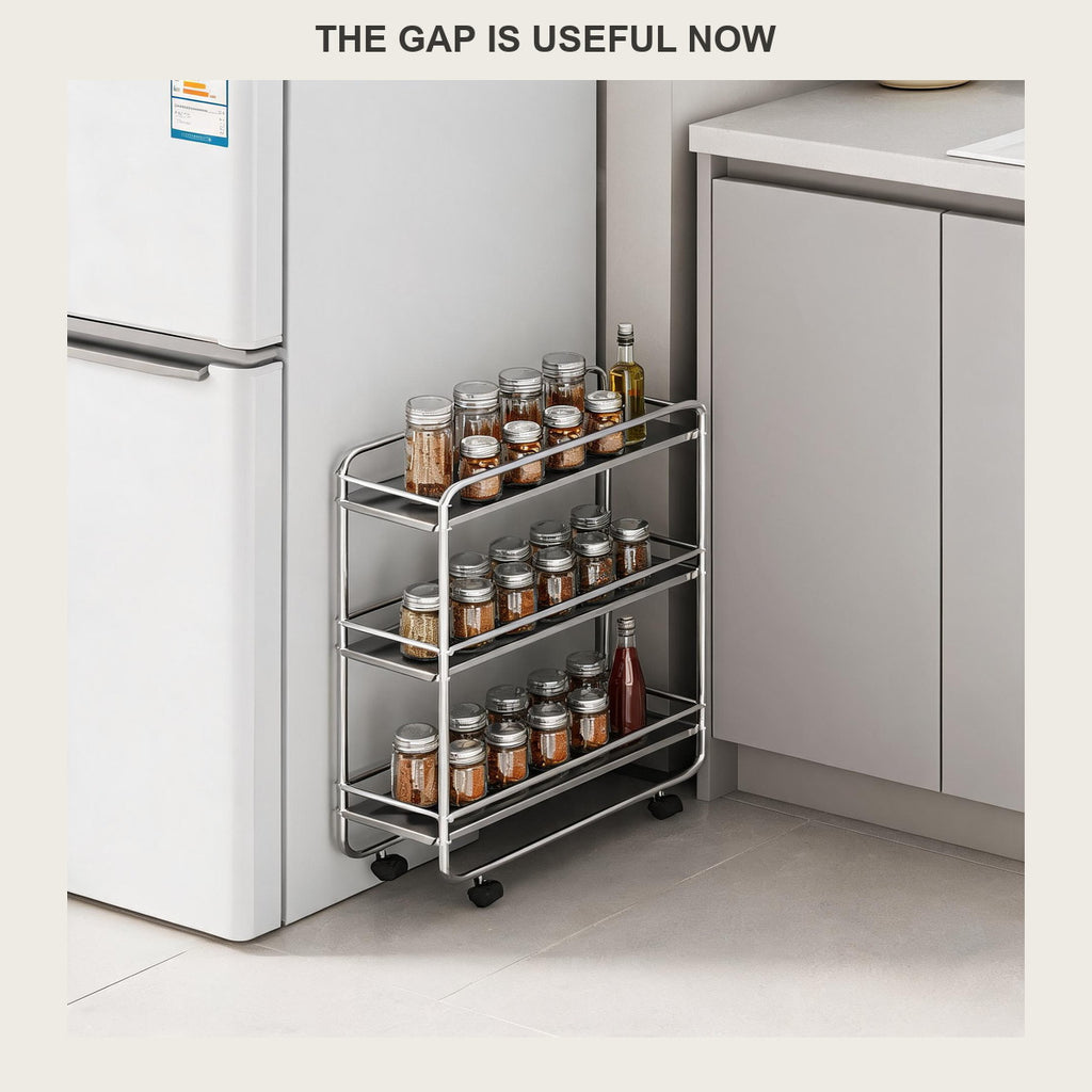 Three-tier rolling cart slotted into the narrow gap beside a white fridge, holding spice jars