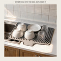 Silicone dish drying mat draining into a kitchen sink